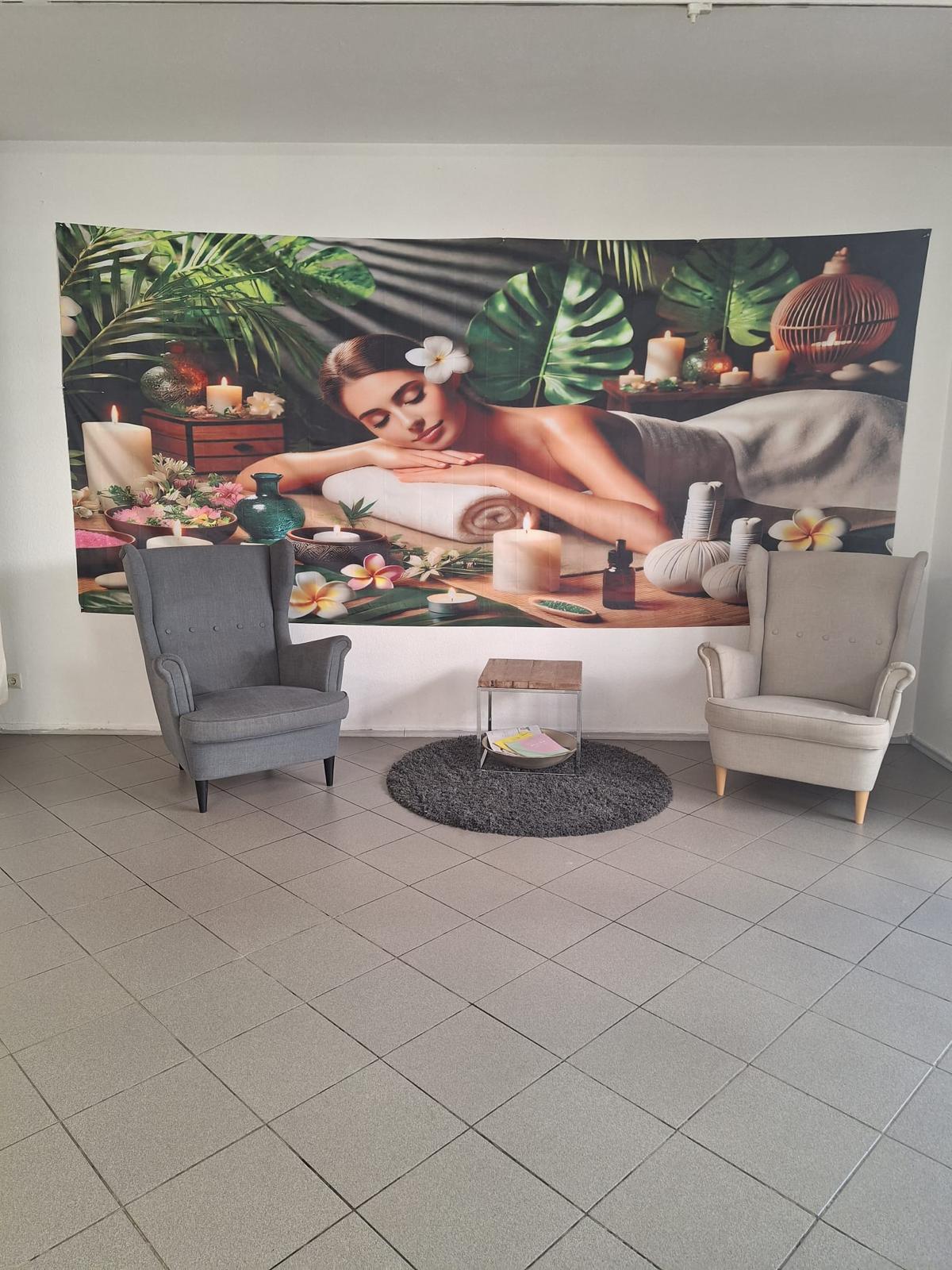 Wartebereich von Suthina's Thai Massage mit Massageposter im Hintergrund